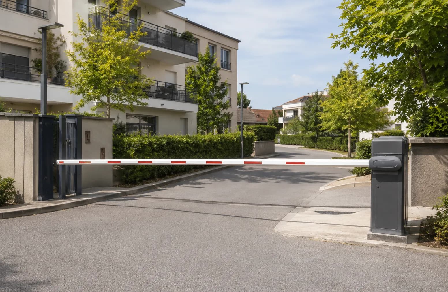 Barrière levante à lisse sécurisant l'entrée d'une copropriété résidentielle