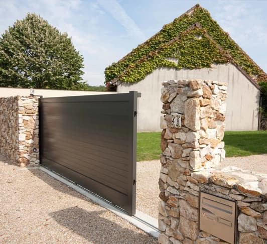 Portail coulissant résidentiel installé devant une maison